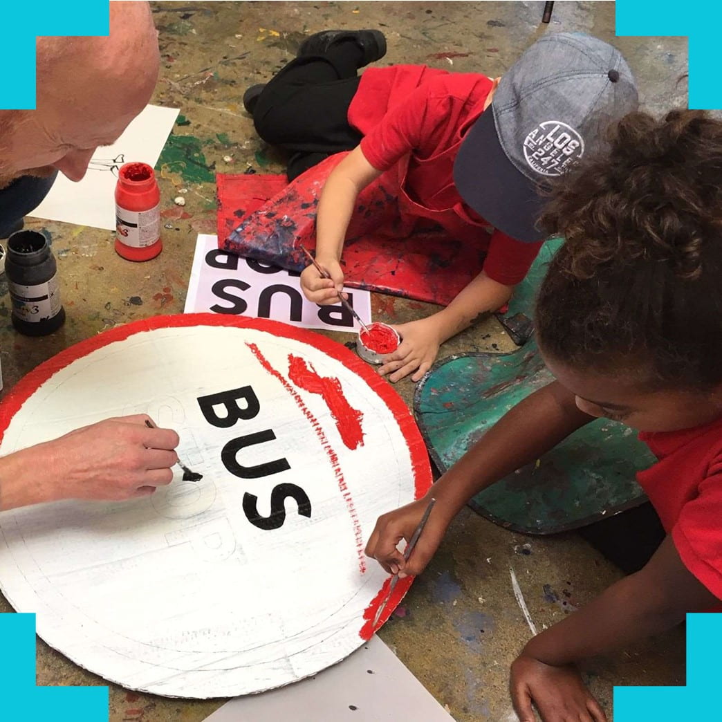 children painting a buc stop sign
