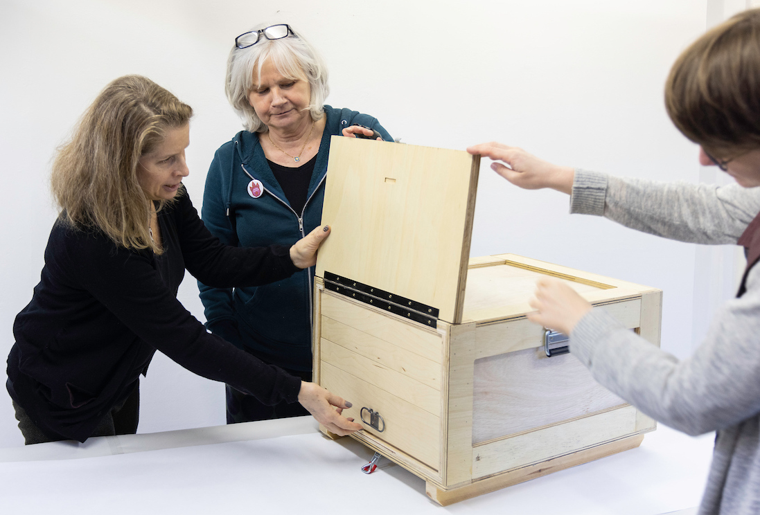 ladies opening up a bespoke wooden box