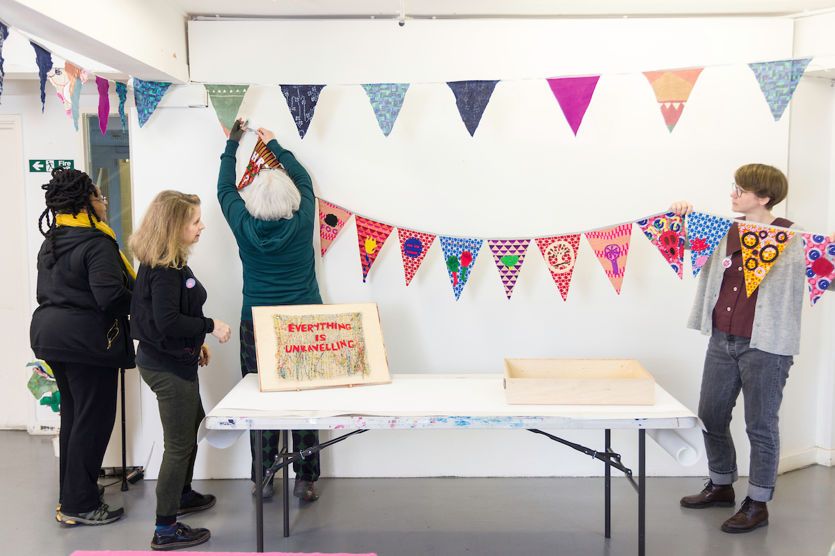 The research team haning up brightly coloured bunting made by the project participants
